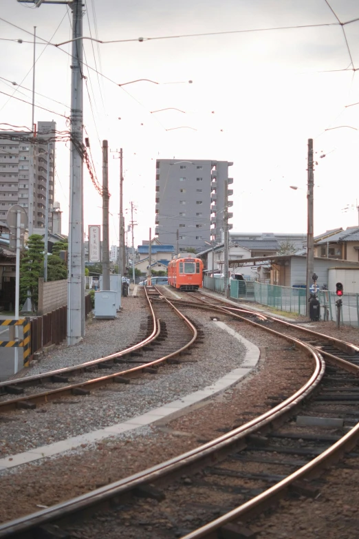 an orange train is on the track near other tracks