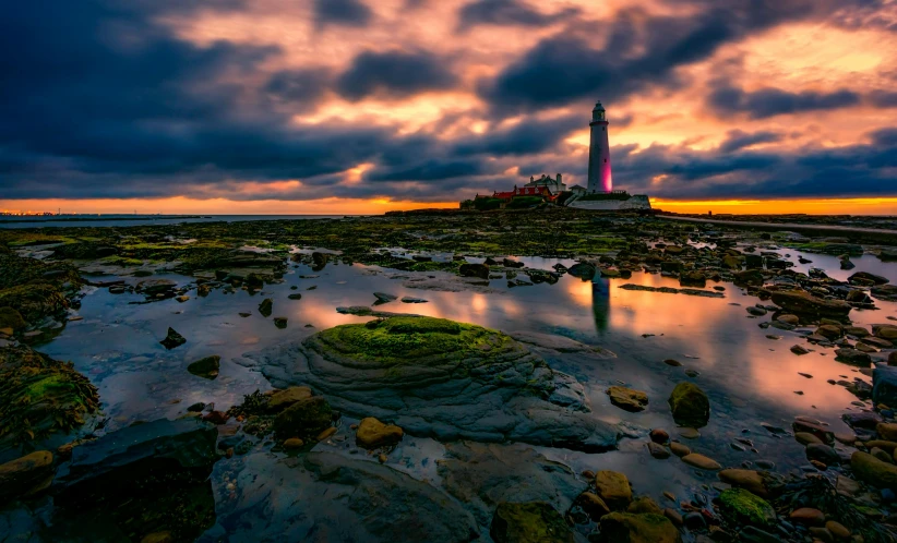 a lighthouse sitting on top of a rocky beach, by Jay Hambidge, pexels contest winner, romanticism, dramatic pink clouds, rock pools, bright colors ultrawide lens, cityscape