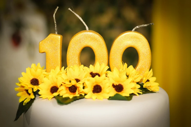 a close up of a cake with sunflowers on it, a portrait, by Yasushi Sugiyama, pixabay, sign that says 1 0 0, on a candle holder, golden number, yellow lanterns