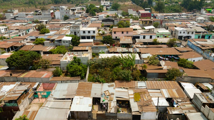 an aerial view of a city with a mountain in the background, by Daniel Lieske, makeshift houses, roof with vegetation, karla ortiz, thumbnail
