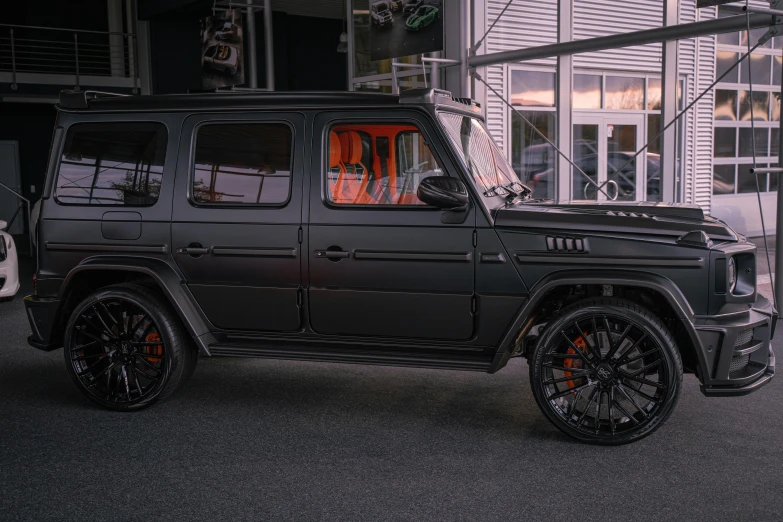 a black jeep parked in front of a building, high end interior, mercedez benz, black and orange, all black matte product