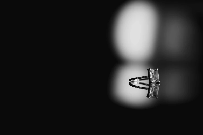 a diamond ring sitting on top of a table, a black and white photo, by Jan Rustem, pexels, minimalism, reflection of led lights, shot on sony alpha dslr-a300, rectangle, marble!! (eos 5ds r