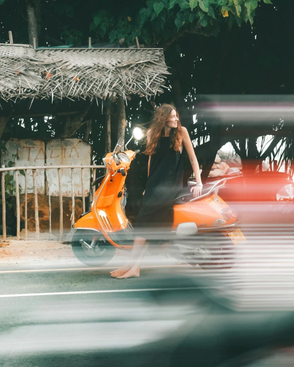 a woman walking across a street next to a motorcycle