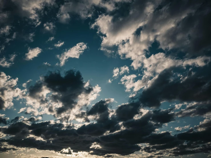 a cloudy sky with a setting sun behind it