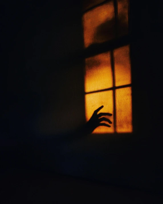 a person reaching out of a window at night, an album cover, pexels contest winner, romanticism, halloween, orange light, snapchat photo, profile image