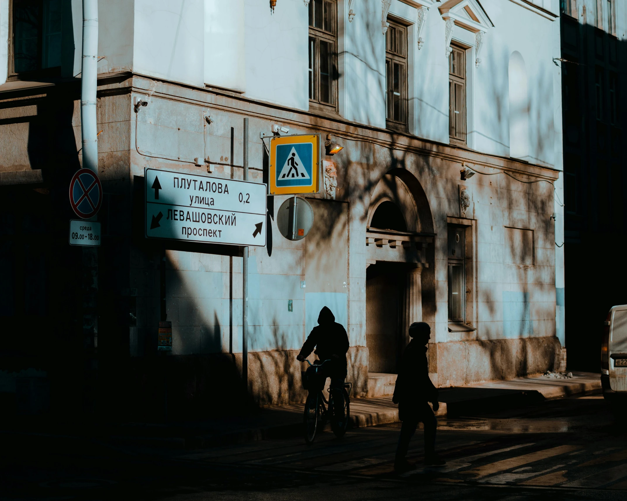 two people walking down the street near a building