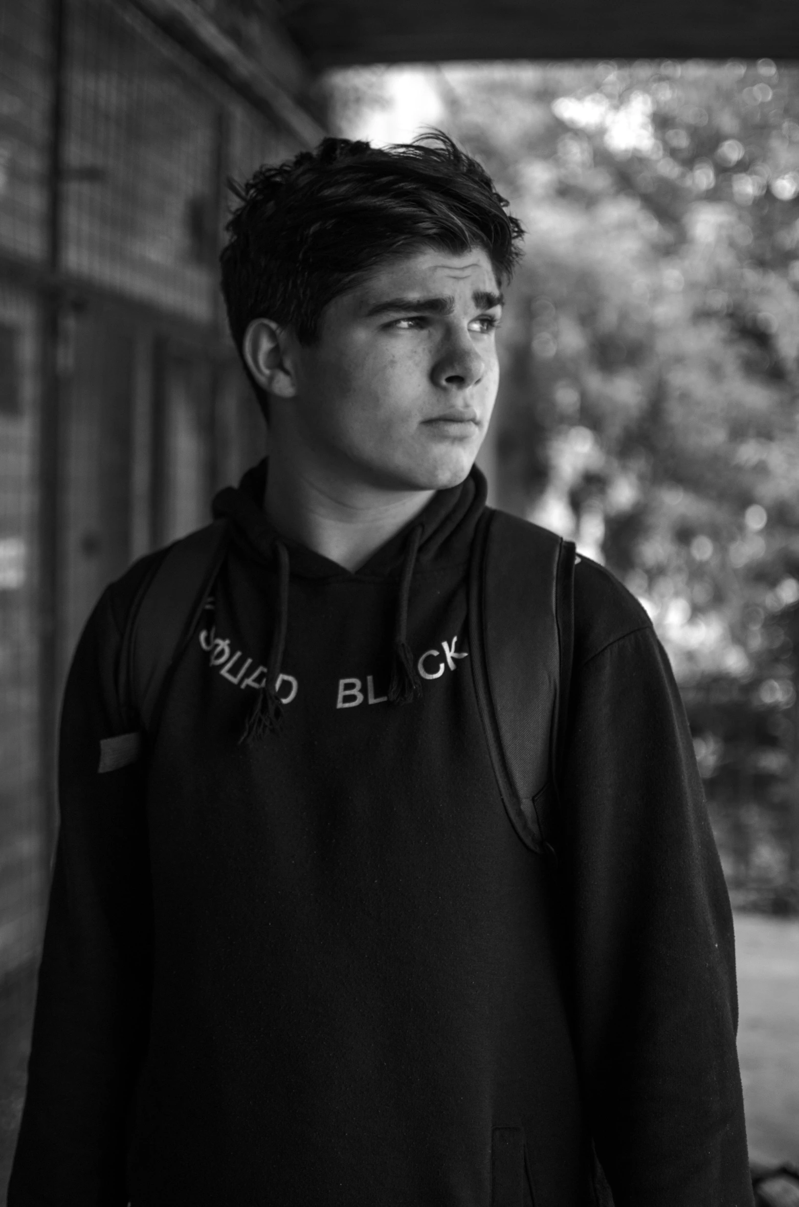 a black and white photo of a man with a backpack, inspired by John Luke, wearing a tracksuit, david marquez, staring!!!!! into the camera, heartbroken