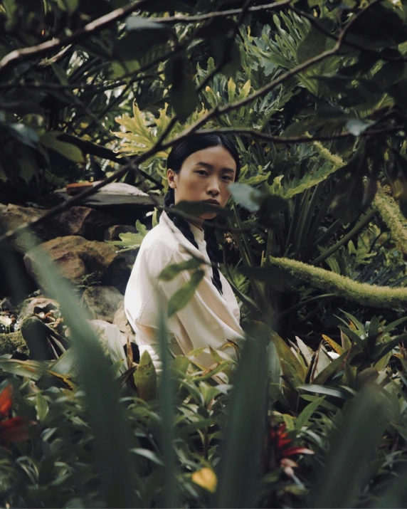 a man standing in the middle of a forest, an album cover, inspired by Ren Hang, unsplash, sumatraism, woman made of plants, wearing white silk robe, standing in a botanical garden, cinematic outfit photo