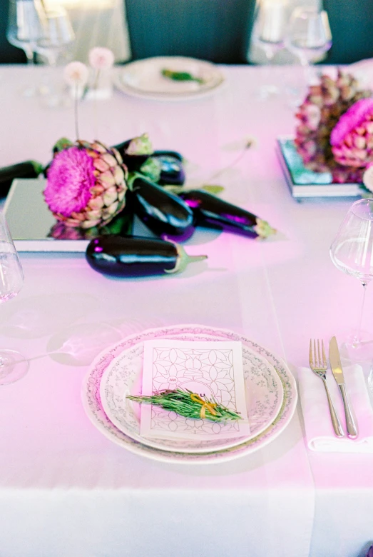 a table that has a bunch of place settings on it, pink violet light, artichoke, vibrant lighting, detail shot