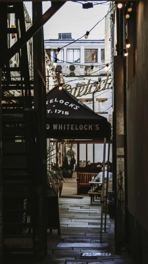 a narrow alley with a sign that says whitelock's, by Derek Chittock, pexels contest winner, art nouveau, a wide open courtyard in an epic, interior of a small, zoomed in, w