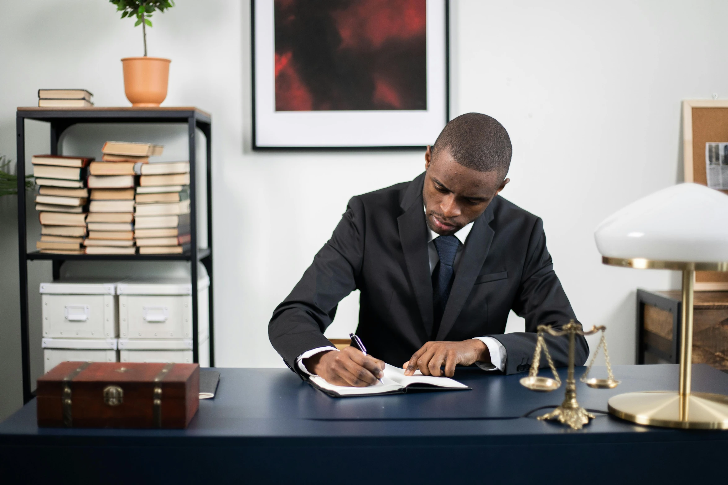 a man sitting at a desk writing on a piece of paper, pexels contest winner, hurufiyya, wearing a black suit, curated collections, keter class, female lawyer