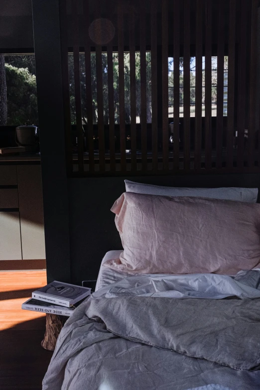 a made bed sitting in a room with wooden slats