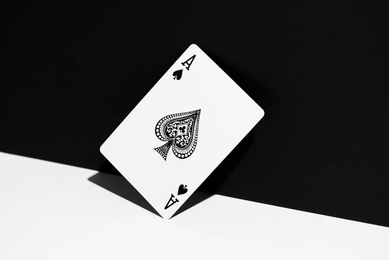 a close up of a playing card on a table, a black and white photo, pexels contest winner, on a flat color black background, 8 k highly detailed ❤🔥 🔥 💀 🤖 🚀, holding an ace card, 4 k hd wallpapear