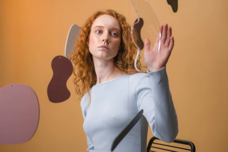 a woman that is standing in front of a mirror, pexels contest winner, kinetic art, ( redhead, waving arms, rounded shapes, transparent glass surfaces