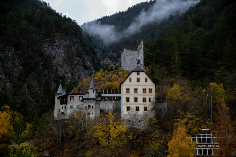 an old house on a mountain surrounded by fog