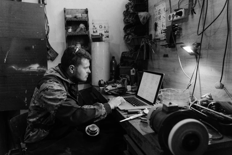 a man sitting in front of a laptop computer, by Petr Brandl, combat photography, mechanic, instagram photo, saatchi art