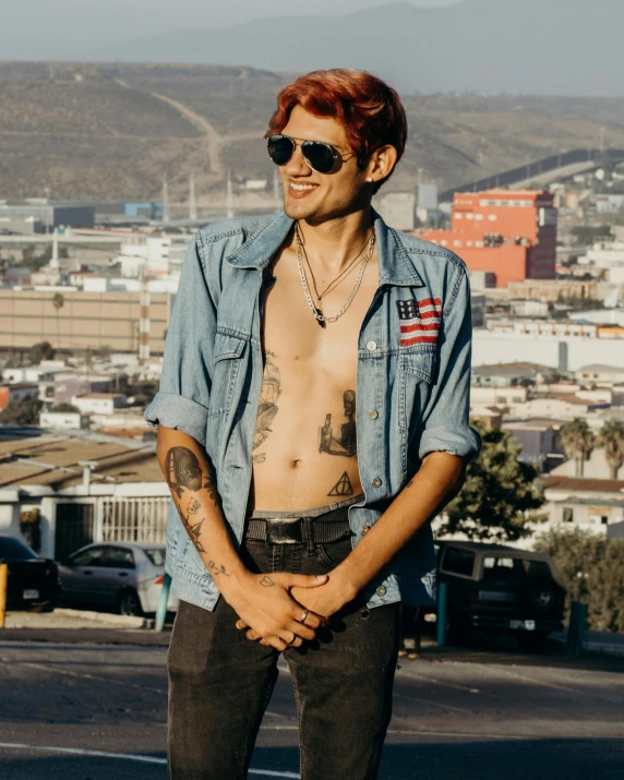 a man standing on a skateboard on a city street, an album cover, by Cosmo Alexander, trending on pexels, red hair and attractive features, no shirt under the vest, chilean, non-binary