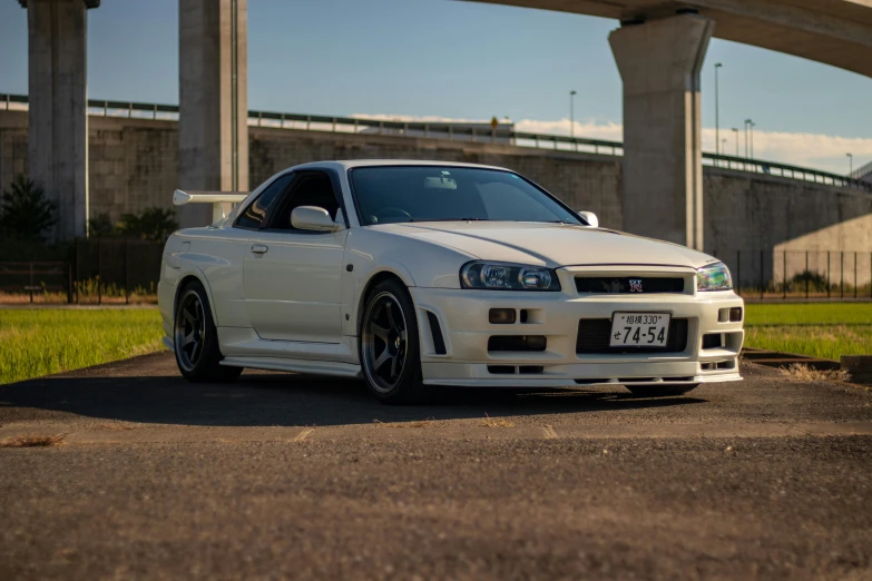 a white sports car parked near a bridge