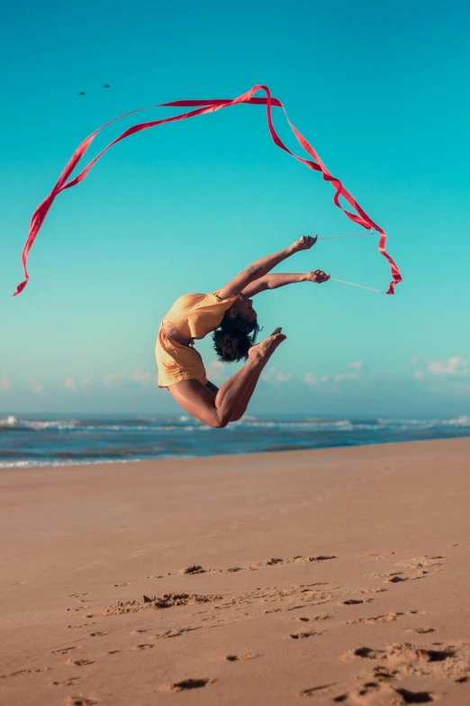 a woman flying a kite on top of a sandy beach, inspired by Elizabeth Polunin, pexels contest winner, arabesque, ribbon, doing splits and stretching, australian beach, profile image