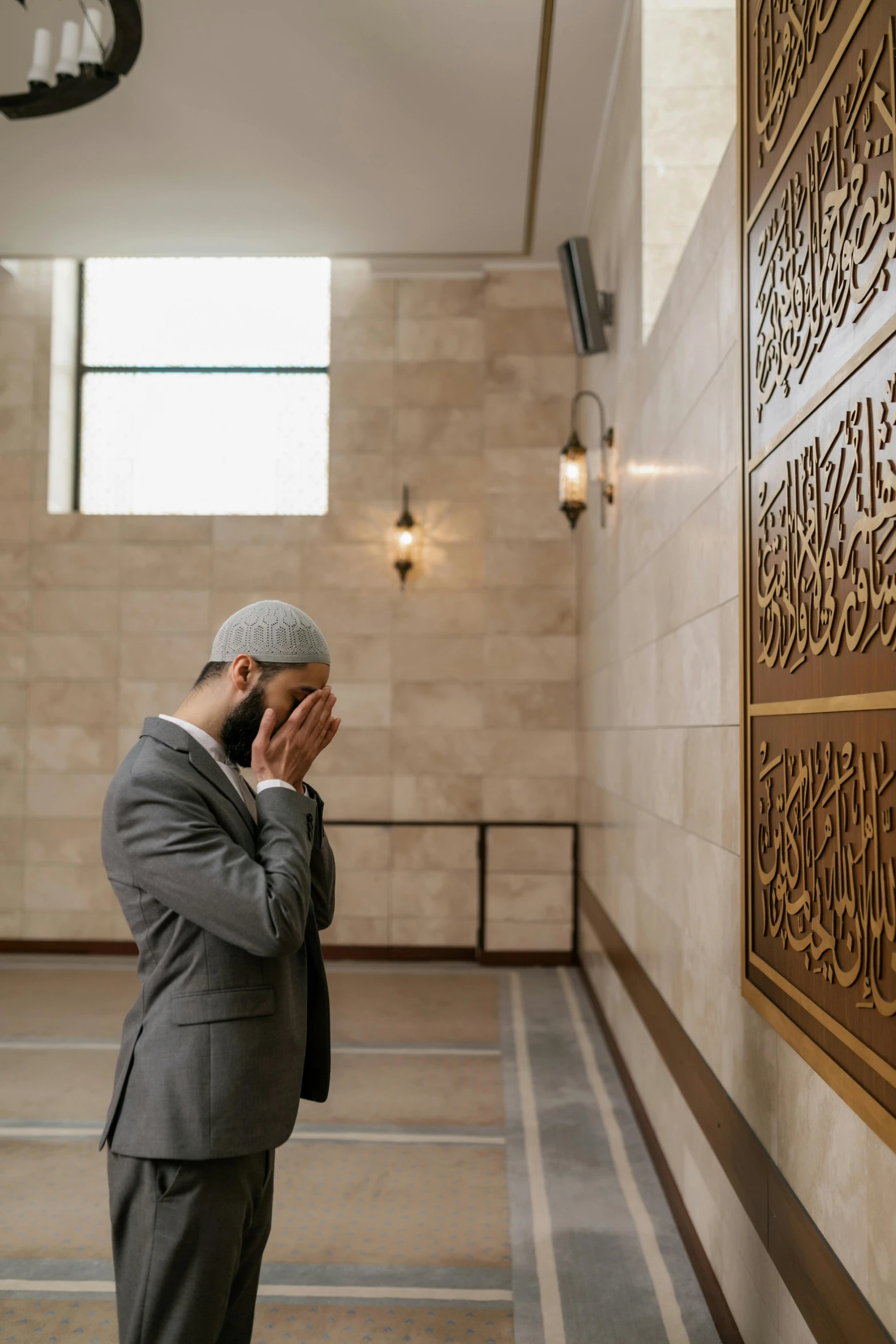 the man is praying on the phone while wearing a suit