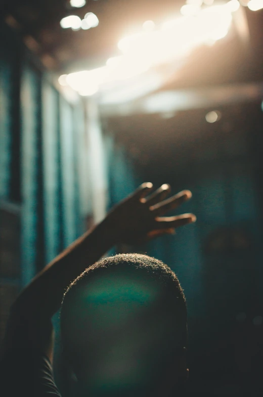 a person raising their hands in the air, a picture, light and space, concerned, portrait featured on unsplash, faded worn, lit from the side