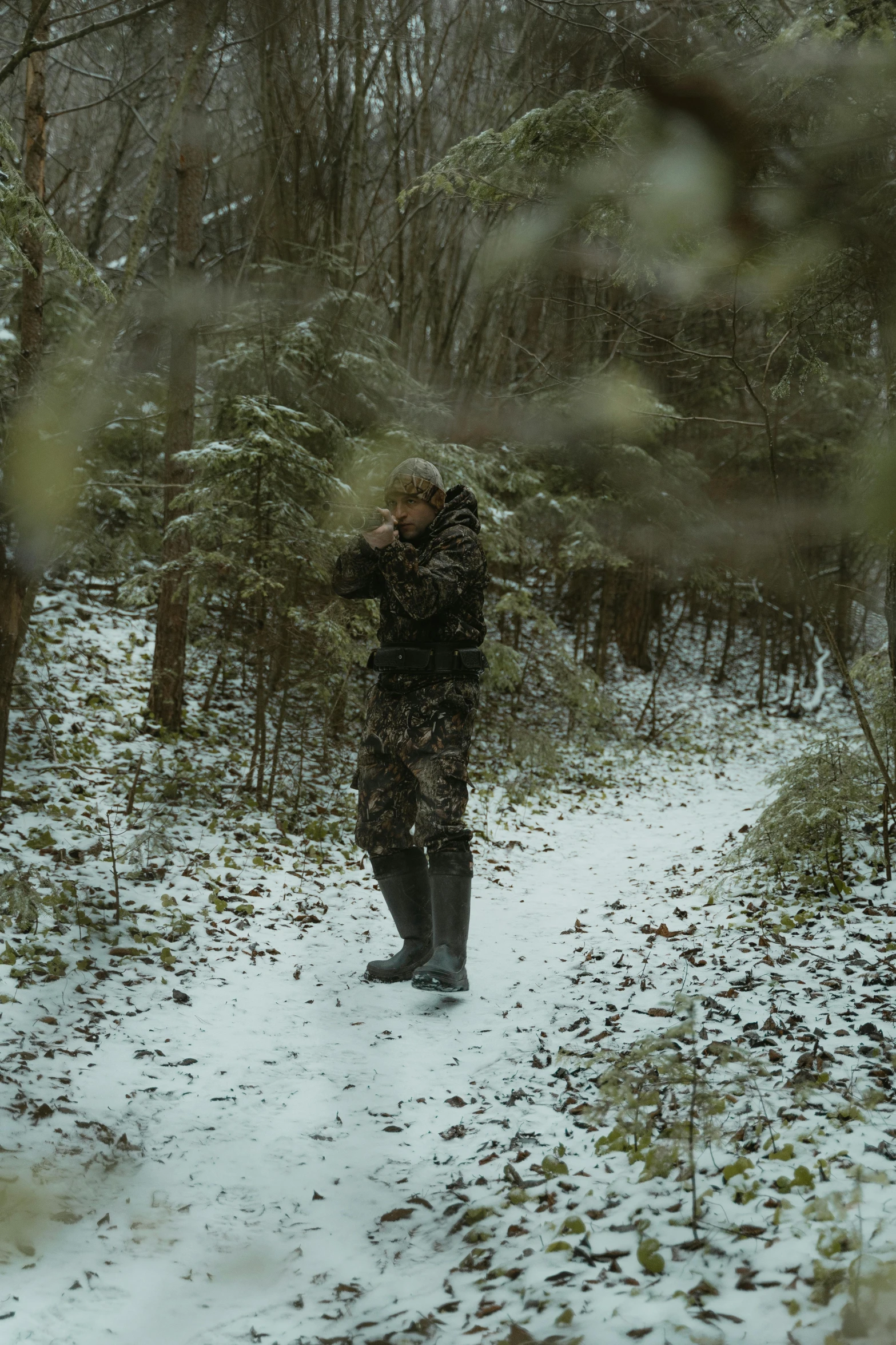 a man that is standing in the snow, jungle camo, cinematography”, brown, distant full body shot