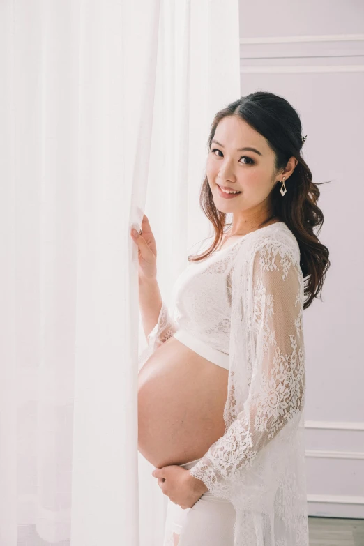 a pregnant woman standing in front of a curtain, inspired by Ruth Jên, unsplash, rococo, japanese collection product, white lace, elegant smiling pose, half body photo