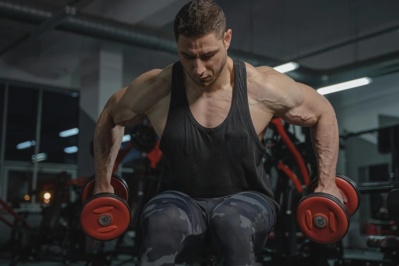 an image of a man performing some heavy dumbbell exercises