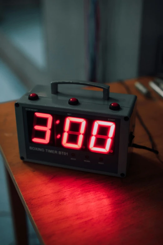 a clock sitting on top of a wooden table, adafruit, giant threes, maroon, high temperature