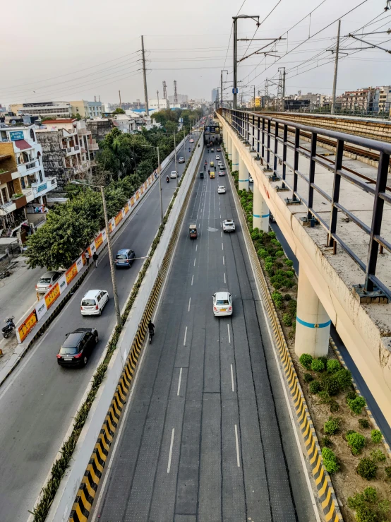 a highway filled with lots of traffic next to tall buildings, by Alejandro Obregón, overpass, promo image, manila, orange line