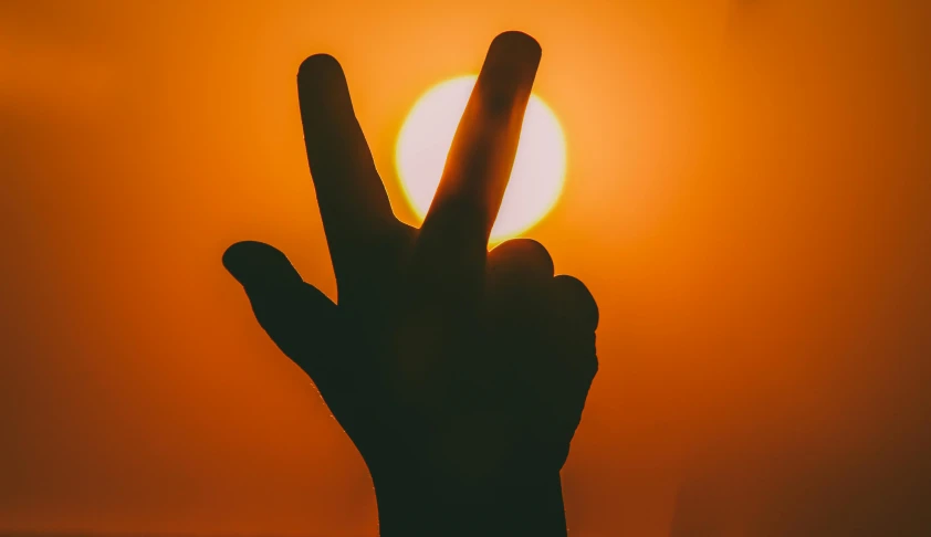 a hand making a peace sign with the sun in the background, an album cover, pexels contest winner, romanticism, orange tone, heat waves, it's getting dark, silhouette :7