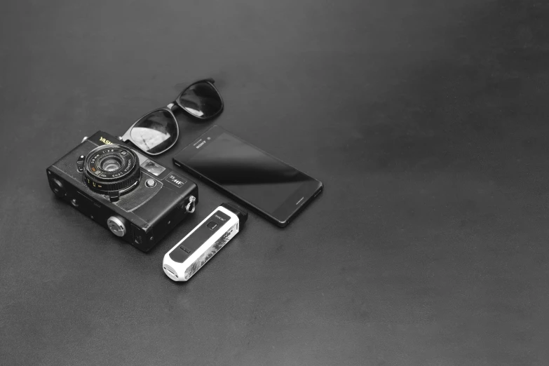 a black and white photo of a camera and a cell phone, a black and white photo, trending on pexels, minimalism, full body shot 4k, rolleiflex, miscellaneous objects, high quality product photo