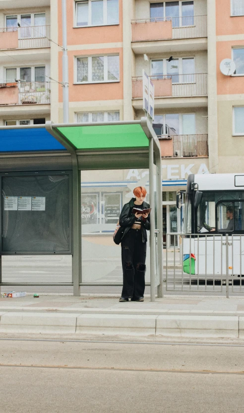 a woman waits at a bus stop waiting for her bus