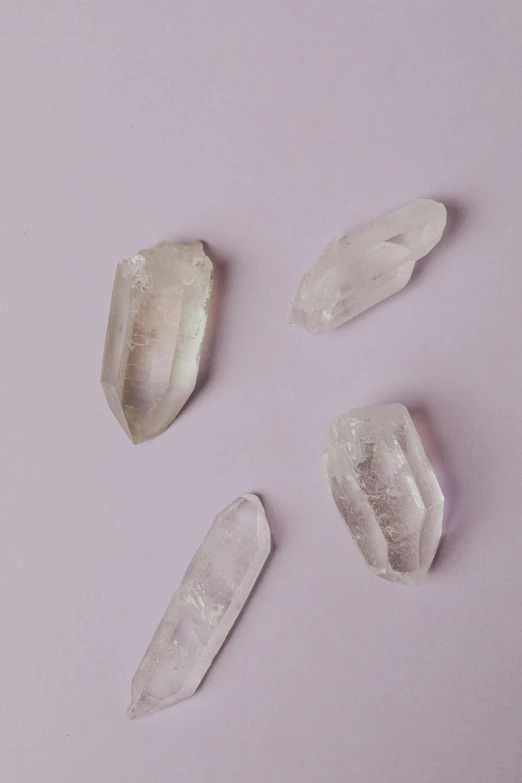 a group of crystals sitting on top of a pink surface, by Morgan Russell, trending on pexels, lavender, made of crystal, white, 24 mm