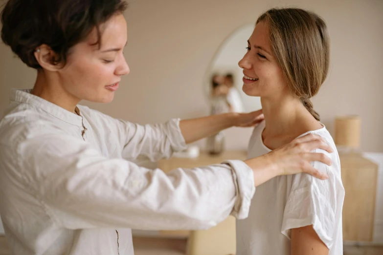 a woman combing another woman's hair in front of a mirror, trending on pexels, acupuncture treatment, wearing collar on neck, earing a shirt laughing, upper body image