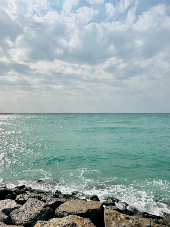 a view of the ocean from a rocky beach, by Robbie Trevino, varadero beach, ((greenish blue tones))