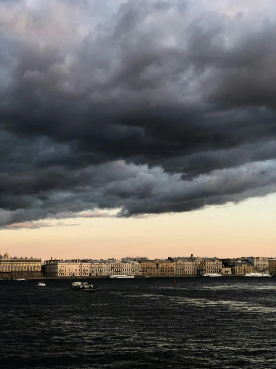 a boat floating down the ocean under some cloudy skies