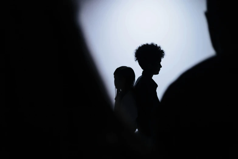 a couple of people standing next to each other, trending on unsplash, realism, black silhouette, ignant, photographed for reuters, schools