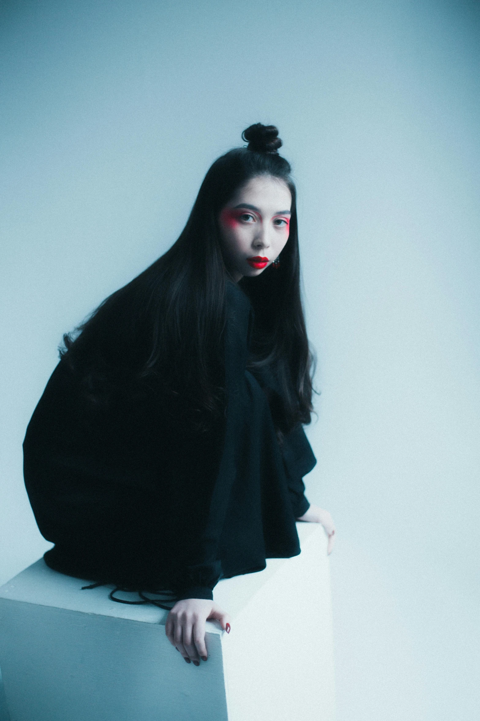 a woman sitting on top of a white box, an album cover, inspired by Taro Yamamoto, pexels contest winner, cruel korean goth girl, jaeyeon nam, portrait of a geisha, in a black hoodie