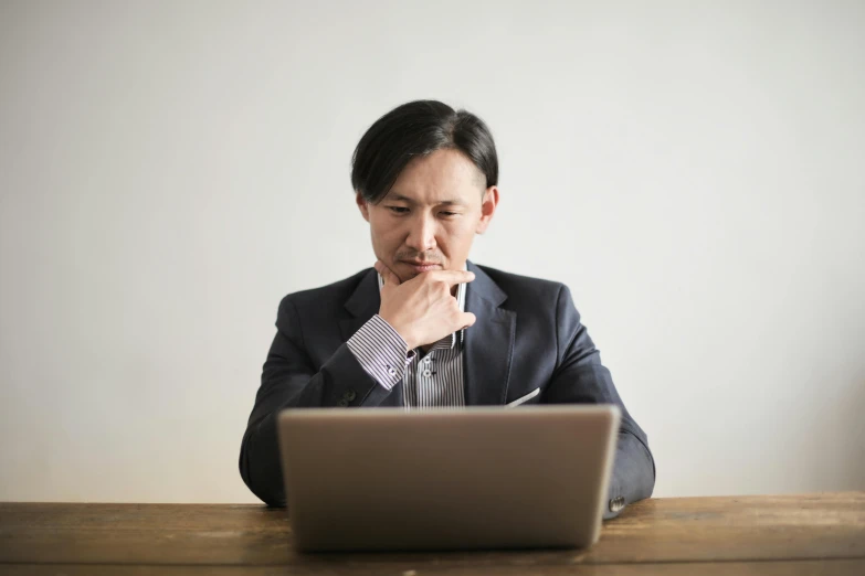 a man sitting in front of a laptop computer, pexels, ethnicity : japanese, pondering, wearing a worn out suit, thumbnail