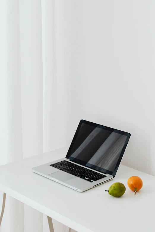 a laptop computer sitting on top of a white table, pexels, fruit, low quality photo, plain background, multiple stories