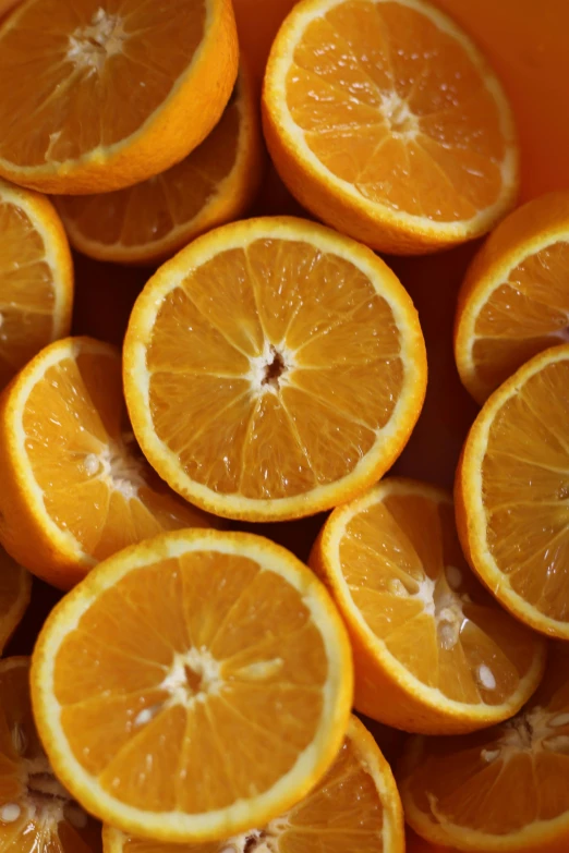 a bowl filled with orange slices sitting on top of a table, closeup of face, zoomed in, organics, subtle detailing
