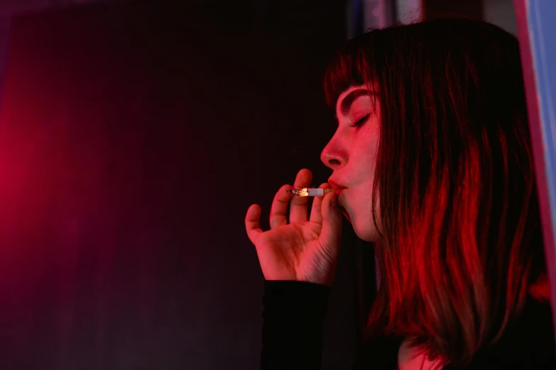 a woman smoking a cigarette in a dark room, inspired by Nan Goldin, pexels contest winner, transgressive art, on a red background, charli xcx, night club, portrait of max caulfield