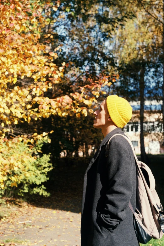 a person with a yellow hat standing near trees