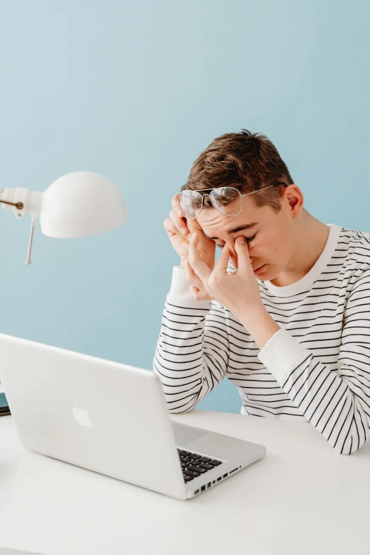 a man sitting at a desk in front of a laptop, trending on pexels, aestheticism, crying and weeping, stripe over eye, non-binary, instagram picture