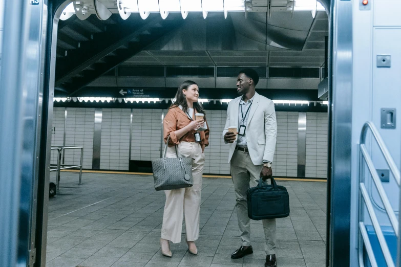 a man and a woman standing next to each other, by Carey Morris, pexels contest winner, happening, subway station, business outfit, ready for a meeting, diverse