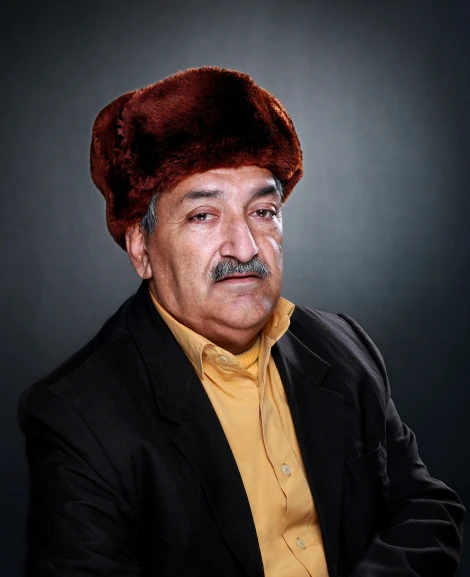 a man in a suit and hat posing for a picture, an album cover, inspired by Arturo Rivera, stuckism, beanie, 70 years old, color photo, reza afshar