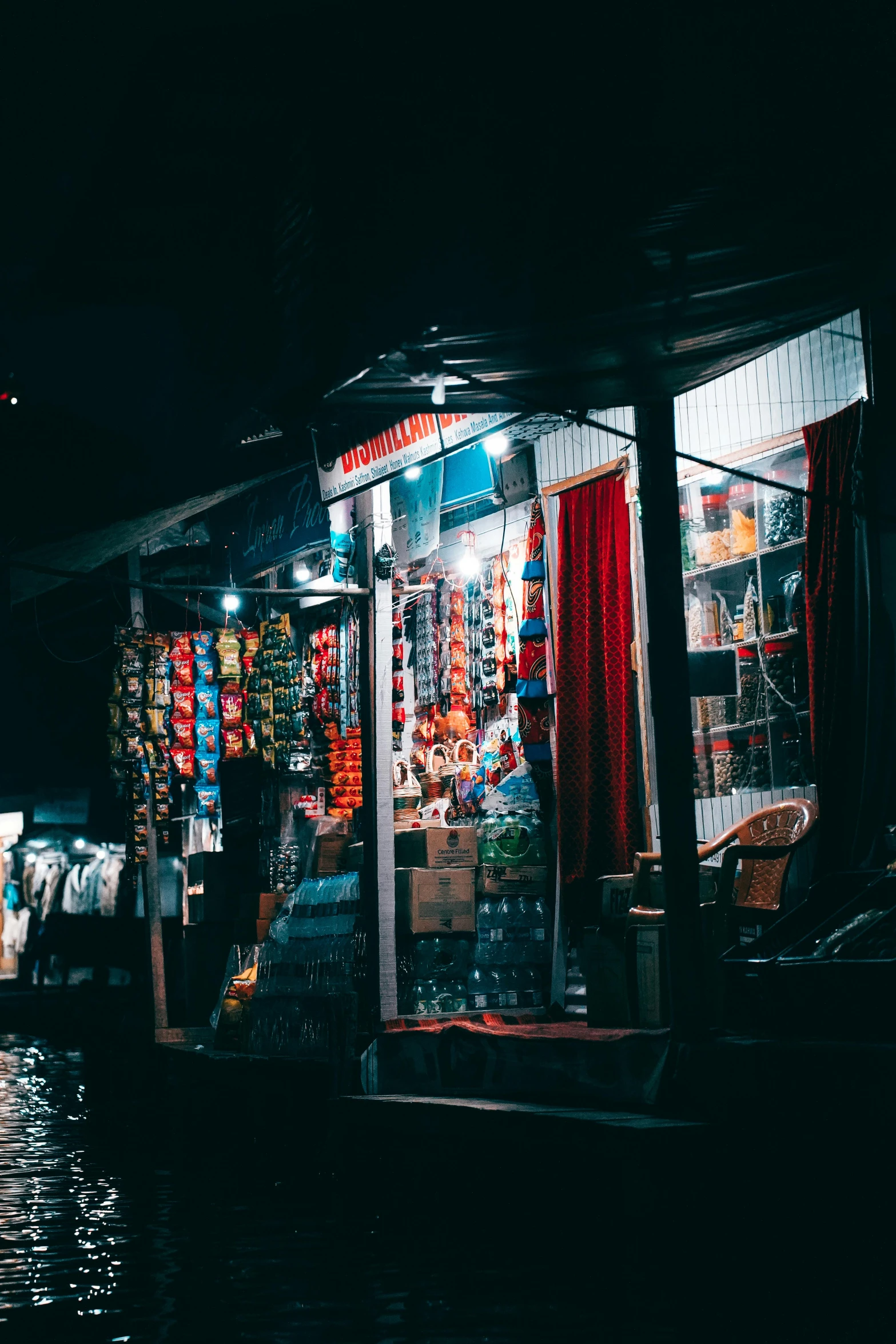 two people outside of a shop at night