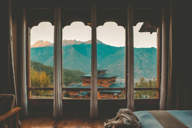 a bed sitting next to two large windows