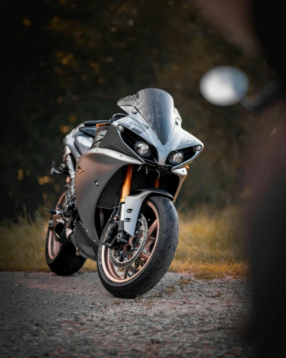 a motorcycle parked on the side of a road, black and silver, r6, soft rim light, automotive